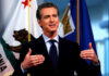 Newsom CAVES on Trans Sports—Comedian Exposes Lie Man speaking with flags in the background