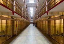Federal Agents CRUSH $50M California Scam Long hallway with prison cells on both sides.