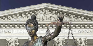 Lady Justice statue in front of courthouse.