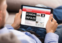 Person reading tablet with headline Scandal Unfolds.