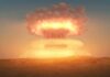 A nuclear explosion creating a large mushroom cloud against a sunset sky