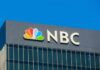 ICE Arrests 185,000—NBC HIDES Critical Detail NBC logo displayed on a corporate building against a blue sky