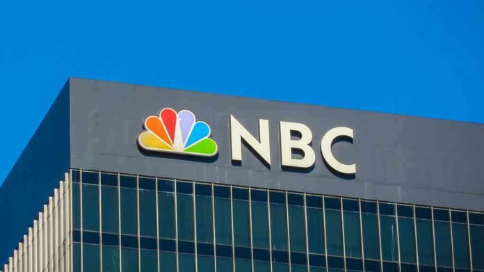 NBC logo displayed on a corporate building against a blue sky