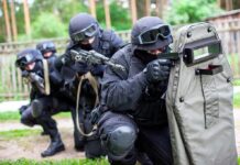 A tactical team in black gear preparing for an operation