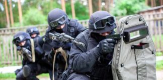 A tactical team in black gear preparing for an operation