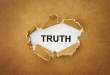 A piece of torn paper revealing the word TRUTH underneath