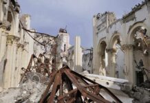 Interior view of a destroyed building with collapsed arches and debris