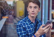 Young man using a smartphone with face recognition overlay
