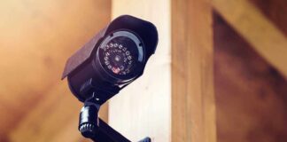 A security camera mounted on a wooden wall