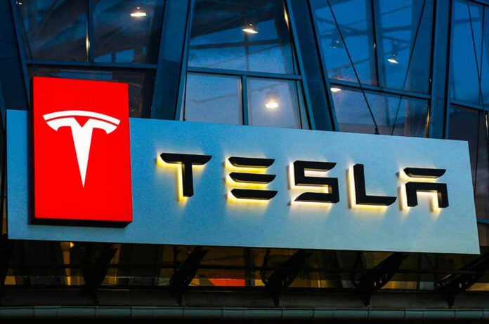 1140629366-2 Tesla logo on a building at night.