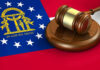 Georgia flag and judges gavel on wooden base.