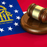 Judge SHIELDS EXPLOSIVE Court MISCONDUCT Claims Georgia flag and judges gavel on wooden base.