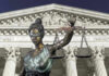 Lady Justice statue in front of courthouse.