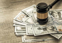 Gavel on a pile of hundred-dollar bills.