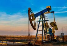 An oil pump jack operating against a sunset backdrop