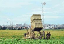 Military defense system deployed in a field with soldiers nearby