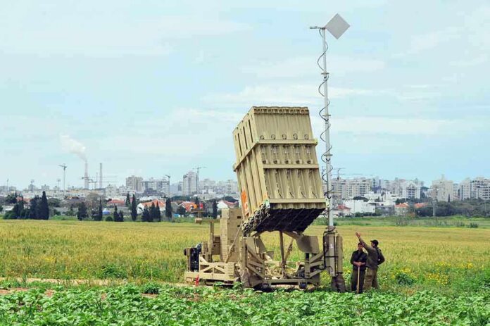 Military defense system deployed in a field with soldiers nearby