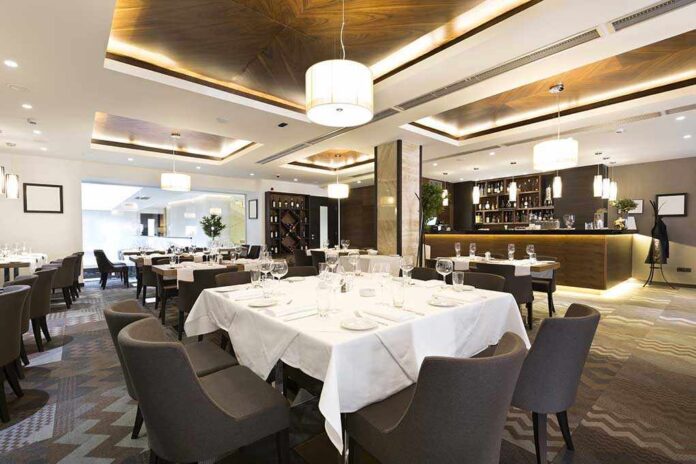 Interior of a modern restaurant with elegantly set tables and a bar area