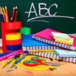 A collection of colorful school supplies including notebooks, pens, and scissors on a desk