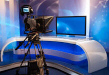 Leak Panic Erupts Inside West Wing TV studio with camera and empty anchor desk.