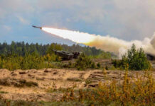The Penn Station Stabbing That Has New Yorkers Asking Hard Questions Military tank firing a missile in forest area.