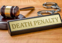 Gavel, handcuffs, and Death Penalty sign on desk.