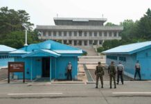 Court Showdown Over U.S. Ebola Plan Military personnel standing near blue buildings at a border crossing