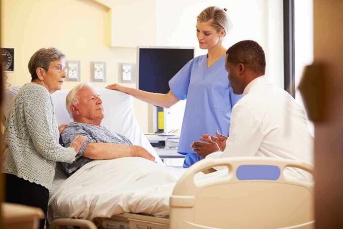 A nurse and a doctor discussing with a patient and his family in a hospital room