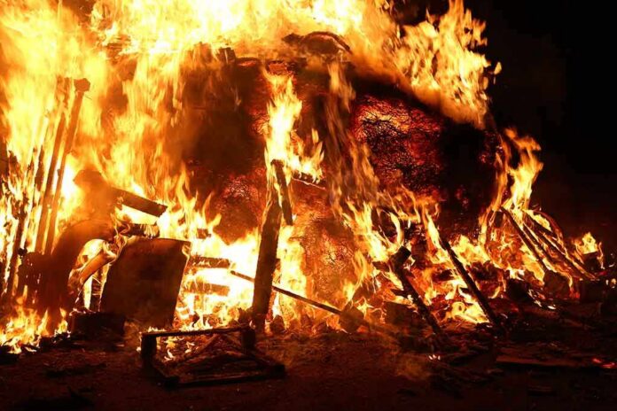 A large fire engulfing debris at night