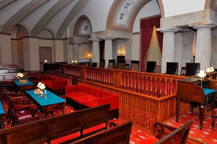 Interior of a historic courtroom featuring wooden furniture and elegant decor