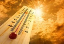 A thermometer displaying temperature against a sunset sky