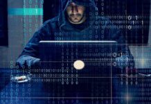Person in hoodie using a laptop with binary code overlay