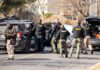 Alabama Couple’s Deaths Spark Investigation Police and sheriff officers gather around vehicles on a suburban street
