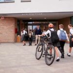 Students in uniforms arriving at a school entrance