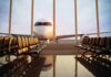 Airplane seen through terminal windows with empty gate seating