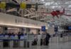 airport security checkpoint with passengers and hanging vintage airplanes