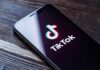 Violent Rhetoric Surges—Feds Move Fast Smartphone displaying the TikTok app logo on a wooden surface