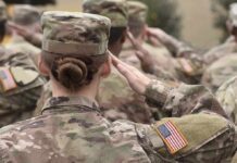 U.S. soldiers in camouflage uniforms saluting