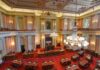 Legislative chamber with red carpet and chandeliers