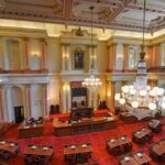 Legislative chamber with red carpet and chandeliers