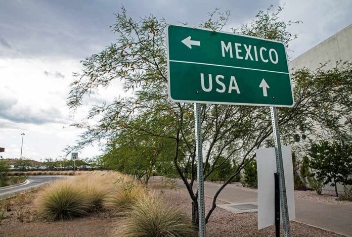 shutterstock_486345745-1 Road sign pointing to Mexico and USA at border area