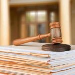 judge's gavel resting on a stack of case files