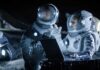 Youngest Planet Ever – Caught in the Act Two astronauts in spacesuits review data on a laptop on a moonlike surface at night