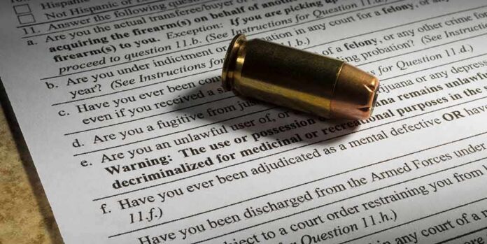 shutterstock_1065503084 Bullet cartridge on firearm purchase form