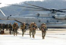 Marines Raise Stakes For Technical Recruits Soldiers disembark and walk past a large military helicopter