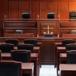 Empty courtroom with wooden benches and judge's bench