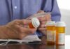 Person holding a prescription bottle and reading medical instructions
