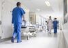 Susan Fuhrmann walking with a nurse in a bright hospital corridor