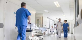 Susan Fuhrmann walking with a nurse in a bright hospital corridor