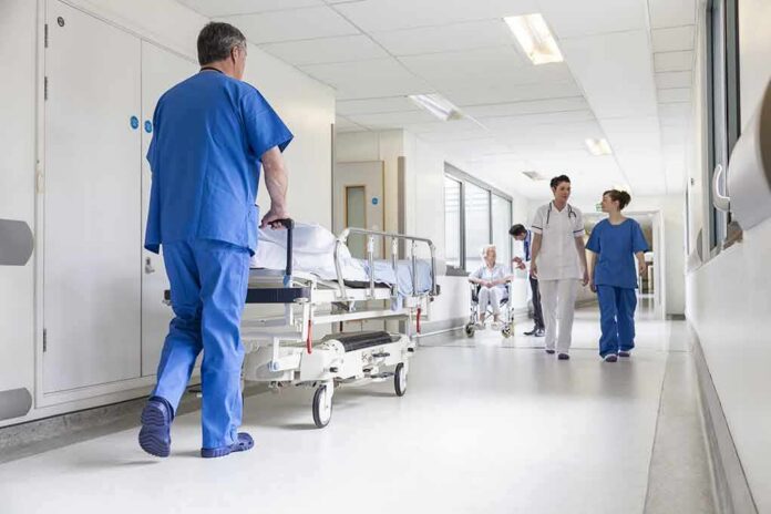 Susan Fuhrmann walking with a nurse in a bright hospital corridor